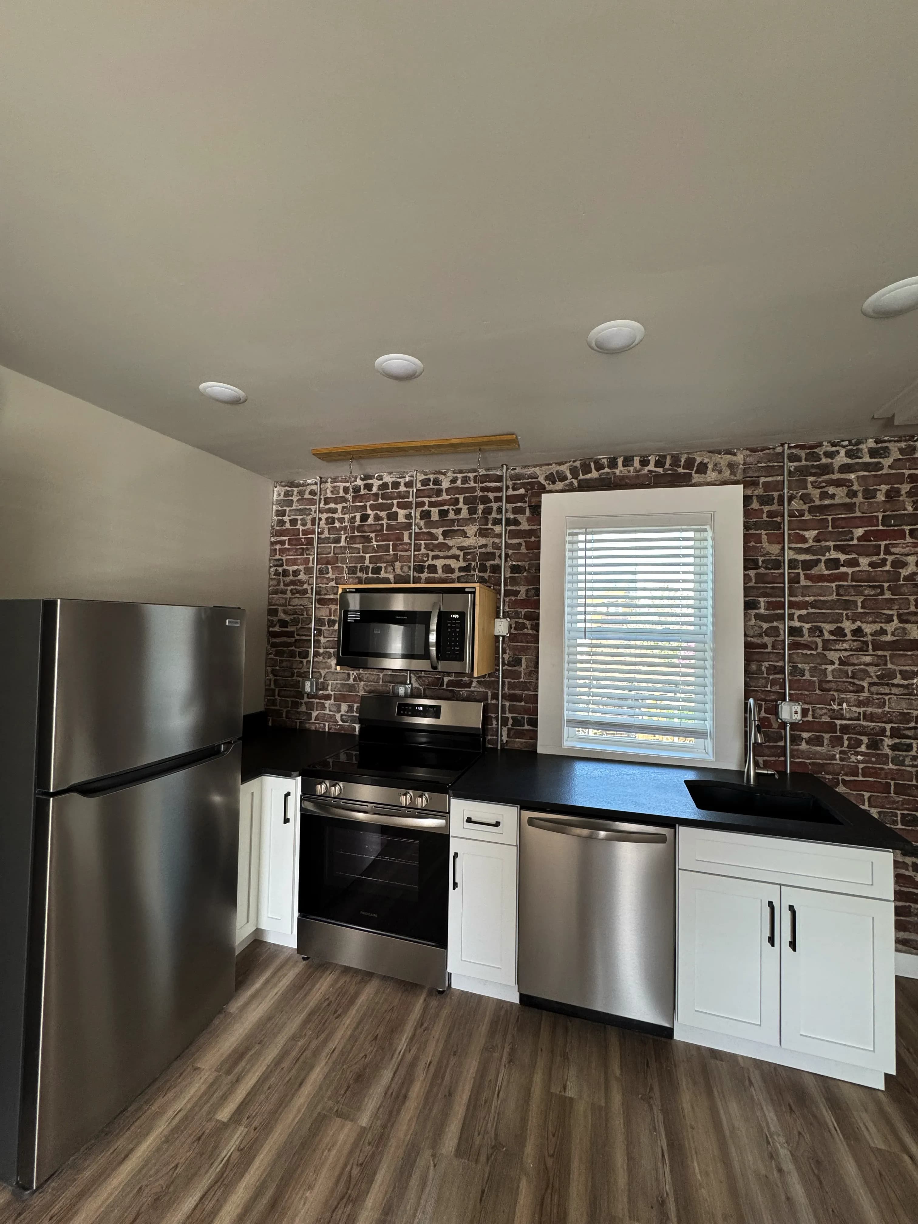 Furnished loft Unit 4 with exposed brick and high ceilings - Brick & Beam Lofts, Columbus Park, Kansas City